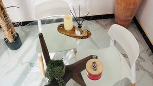 A glass-top table with candles, a small potted plant, and a terracotta pot with a plant. - 2-bedroom apartment in charming Dakar with AC and comfort (Dakar)