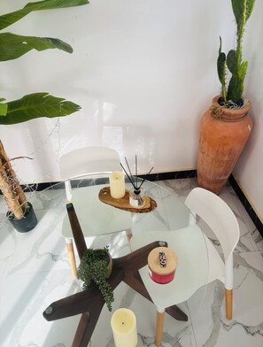 A glass-top table with candles, a small potted plant, and a terracotta pot with a plant. - 2-bedroom apartment in charming Dakar with AC and comfort (Dakar)