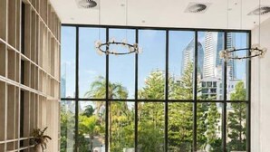 Amplia habitación con ventanas grandes, muebles modernos y vistas a la ciudad.