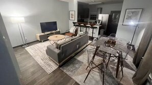 A modern living room with a sofa, TV, dining table, and chairs. - Entire home in Houston central, Texas (Houston)