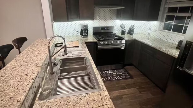 A modern kitchen with granite countertops, a stainless steel sink, a built-in oven, and a coffee maker. - Entire home in Houston central, Texas (Houston)