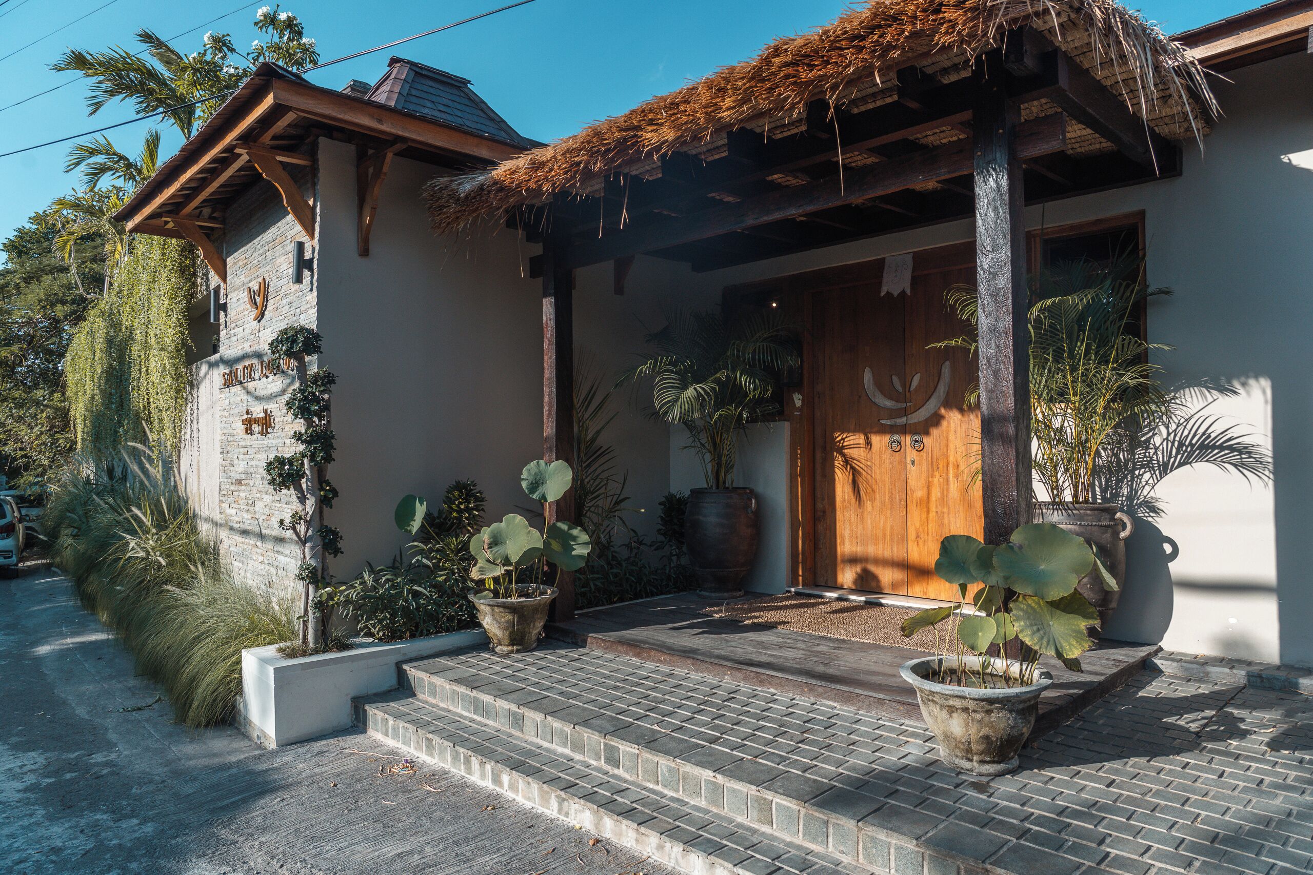A building with a thatched roof, a wooden door, and a brick entrance.