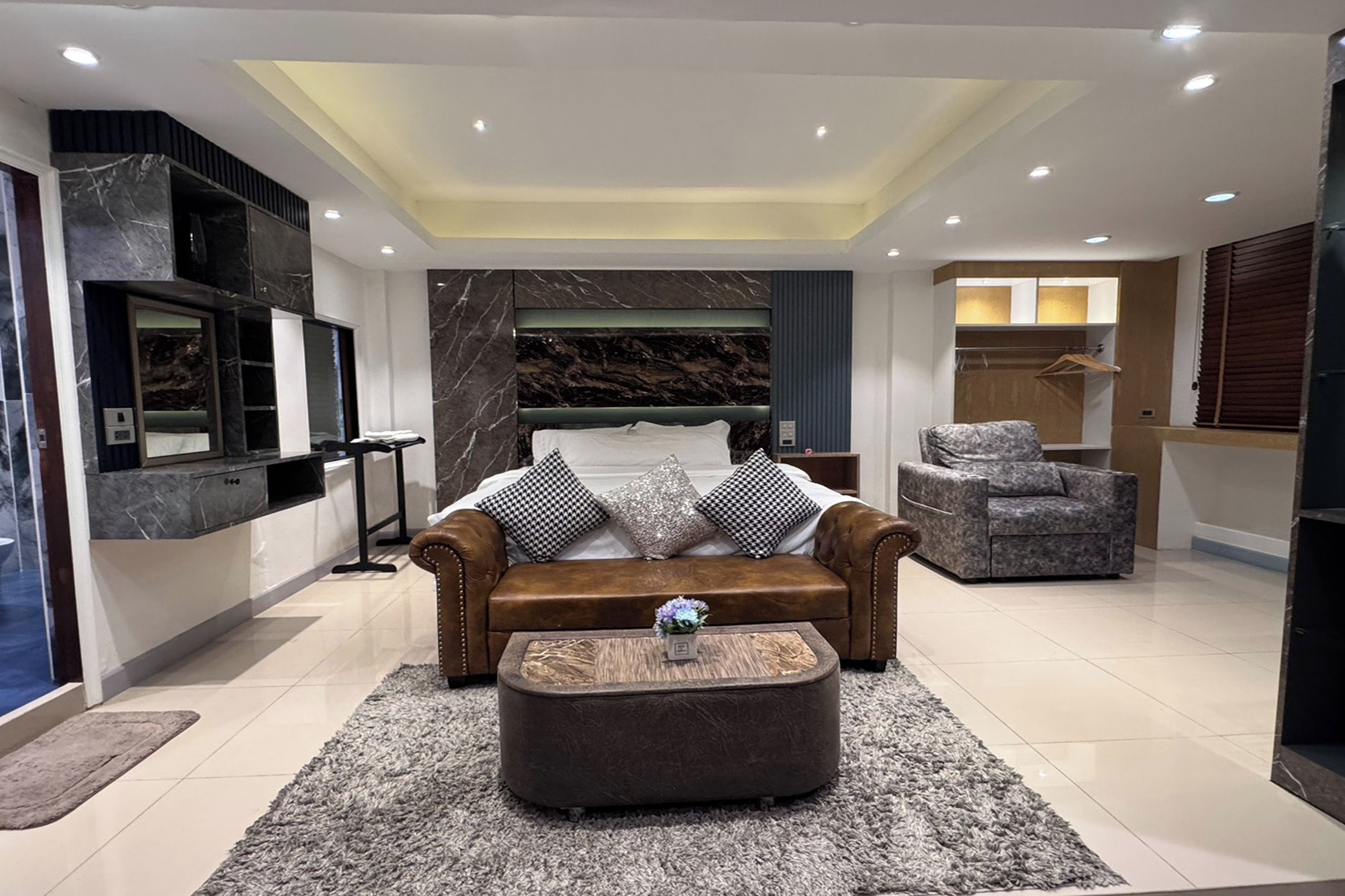 A modern living room with a sofa, ottoman, and a decorative rug.