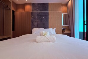 A hotel room with a large bed, wooden paneling, a marble accent wall, and a view of the sky through a window. - M&M Rooftop Pattaya (Pattaya)