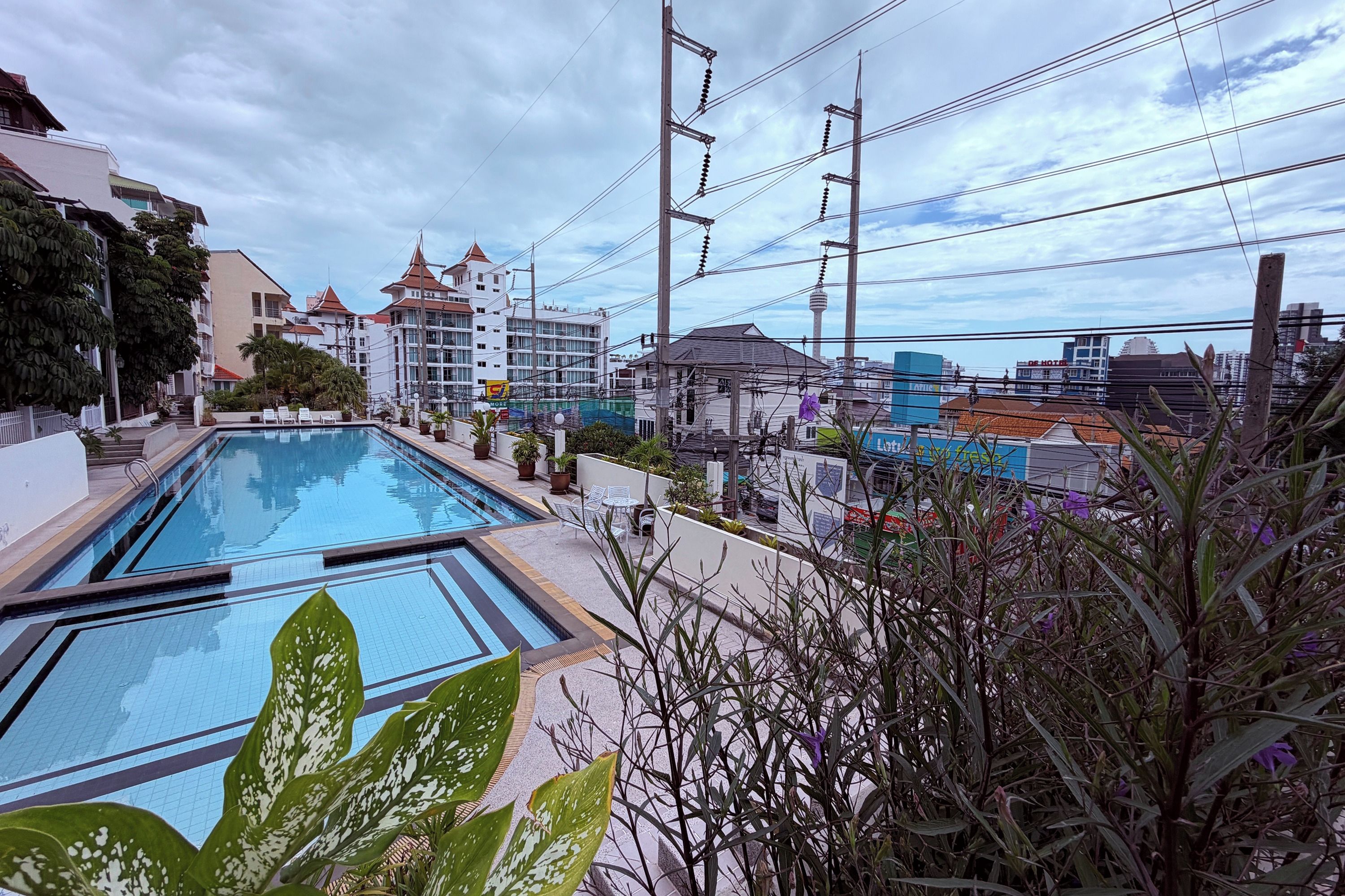 Una piscina con vistas a edificios y un cielo despejado.