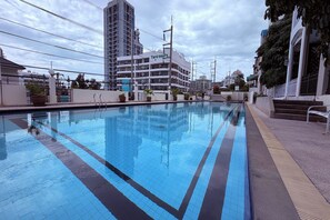 A swimming pool with a clear blue water surface, surrounded by a walkway and potted plants. - M&M Rooftop Pattaya (Pattaya)