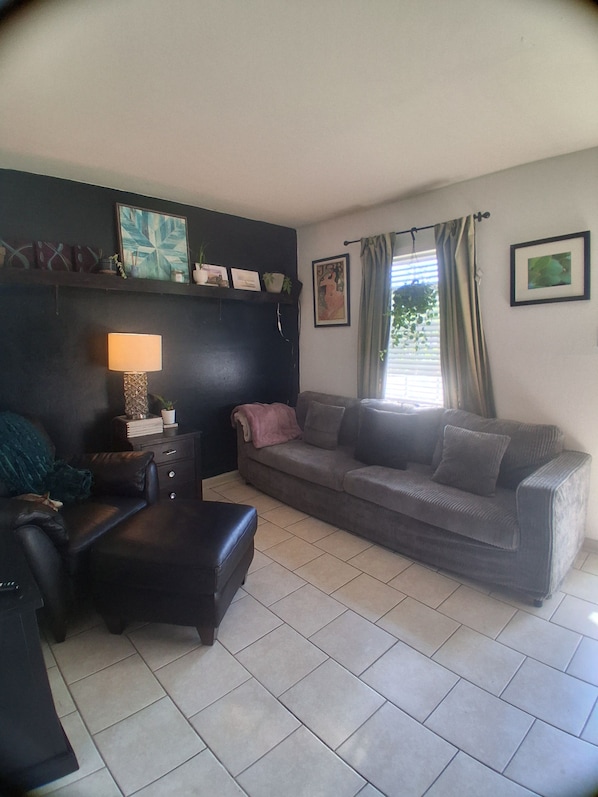 Una sala de estar con un sofá, una mesa de centro, una lámpara y una chimenea.