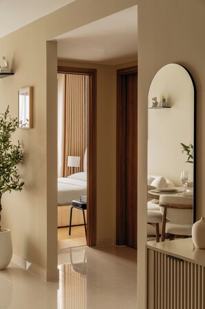 A hotel room with a bed, a chair, a table with a glass, and a potted plant. - Maison De Gu 2BR Co Giang - District 1 (Thành phố Hồ Chí Minh)