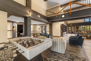 A spacious living area with a foosball table, comfortable seating, a staircase, and a view of the outdoors. - The Springs at River Run - Walk to Gondola - Pool w/ Slide - Hot Tubs - Sleeps 4 (Keystone)