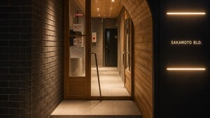 A hallway with a wooden door, a sign, and a fire safety sign. - BACOWA AWAZA (Nishi-ku, Osaka)
