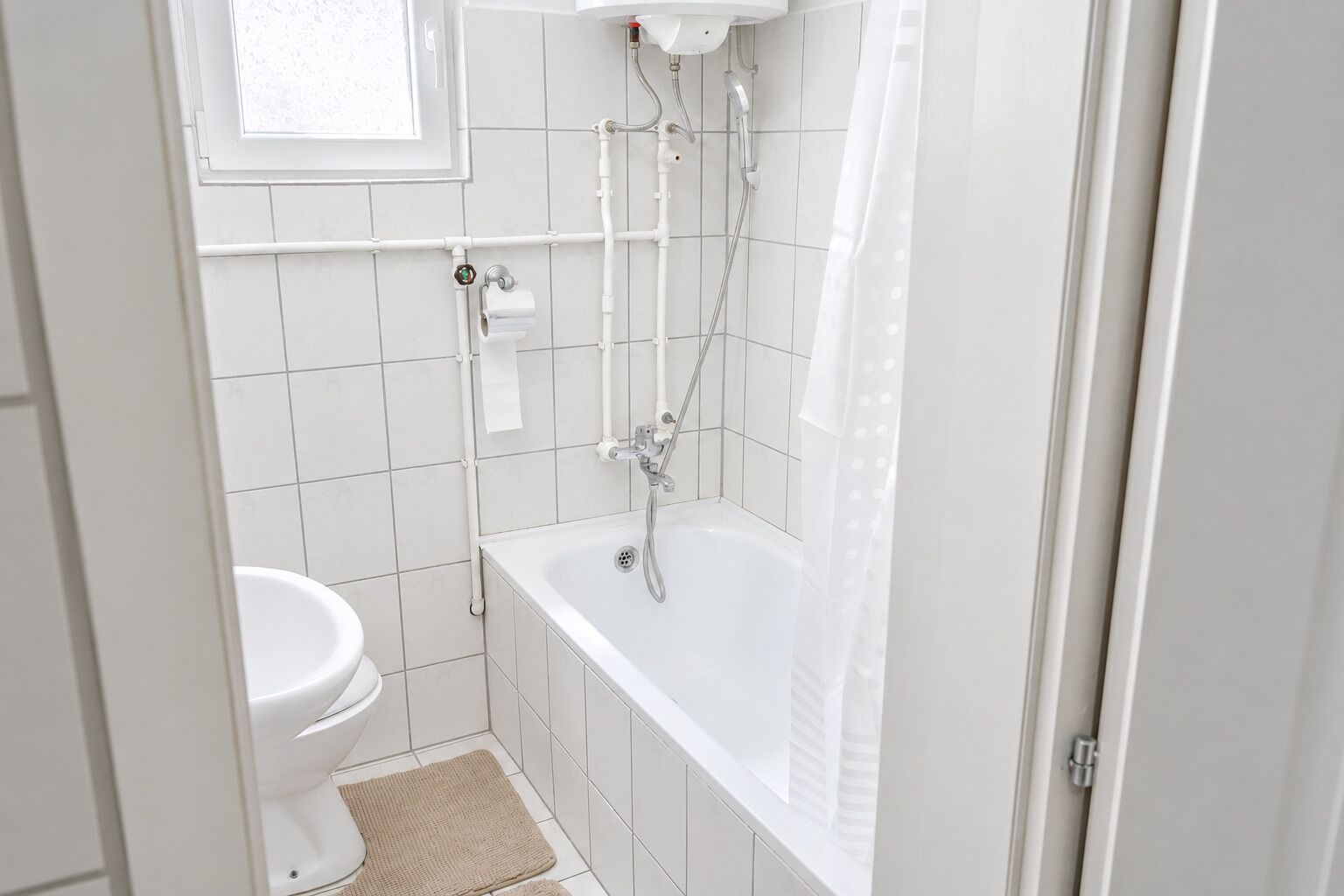 A bathroom with a toilet, a bathtub, and a shower.