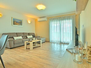 A living room with a sofa, coffee table, and a television. - Villa Mušković by Interhome (Tinjan)