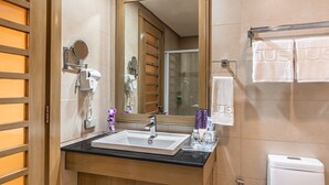 A bathroom with a sink, mirror, towel rack, and a toilet.