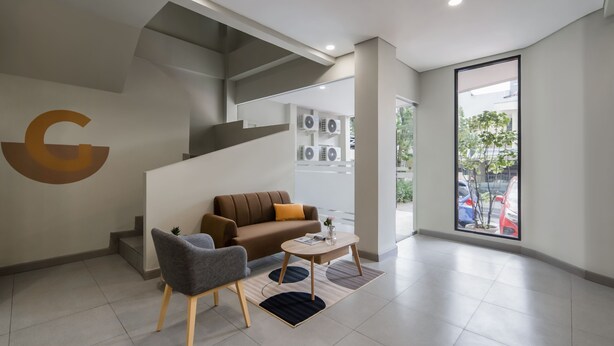 A modern interior with a staircase, a sofa, a chair, and a coffee table.