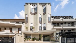 A modern building with a 'cove' sign, multiple balconies, and a gated entrance.