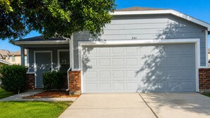 A residential garage with a white door and garage door, number 834, adjacent to a house with a brick foundation and a small front yard. - 3-bedroom house in peaceful Houston with cool AC breeze (Houston)