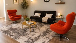 A living room with a sofa, two armchairs, a coffee table, a floor lamp, a mirror, a plant, and a small side table. - 3-bedroom house in peaceful Houston with cool AC breeze (Houston)