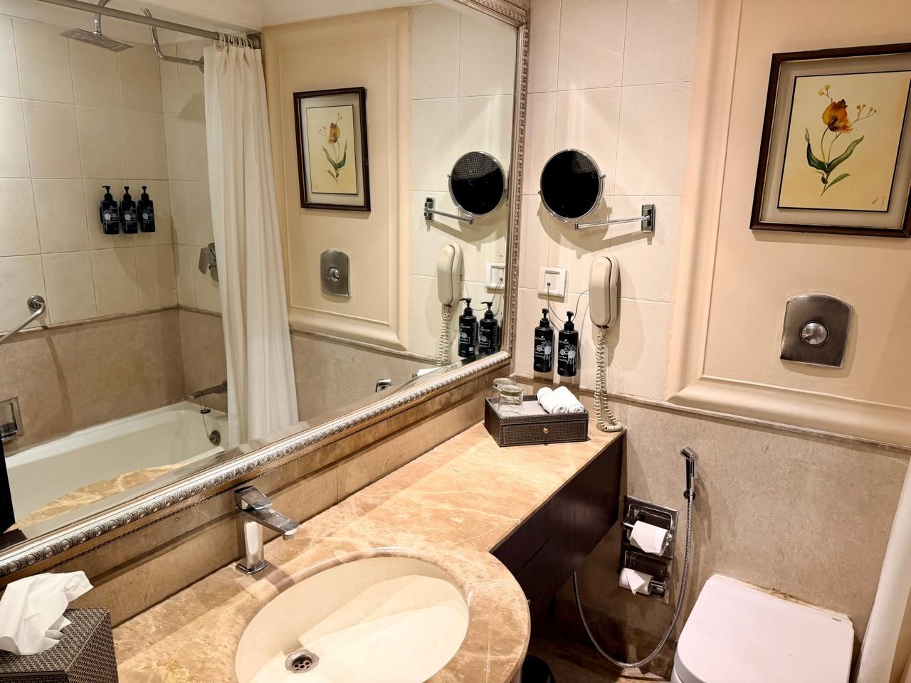 Un baño con bañera, lavabo, inodoro y un espejo grande.