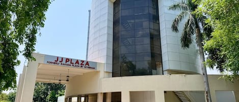 A modern building with a sign reading 'JJ Plaza' and a staircase leading to the entrance.