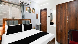 Ein Schlafzimmer mit Bett, Schrank, Spiegel, Waschbecken und einer Klimaanlage.
