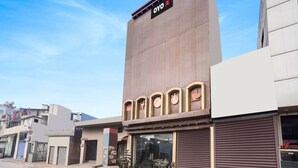 Un edificio moderno con un'insegna che riporta 'OYO' e una vetrina con un'impalcatura abbassata.