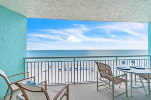 A balcony with a view of the beach, white railing, and a table with chairs. - Top Floor Beachfront with Amazing Views! Heated Pool, Free Parking, Free Activities! ~ 506 Chateaux (Indian Shores)