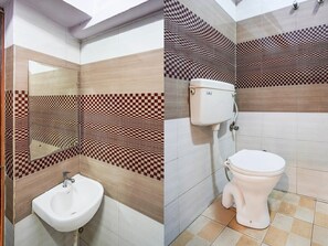 A bathroom with a sink, toilet, and checkered wall tiles. - Saver Double Hotel Shivam Residency (Dehradun)