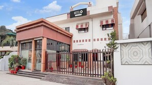 A hotel with a prominent sign, a gated entrance, and a small porch area with potted plants. - Saver Double Hotel Shivam Residency (Dehradun)