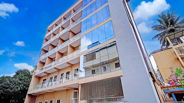 A multi-story building with balconies, large windows, and a clear sky. - Saver Single Bangalore Inn (Bengaluru)