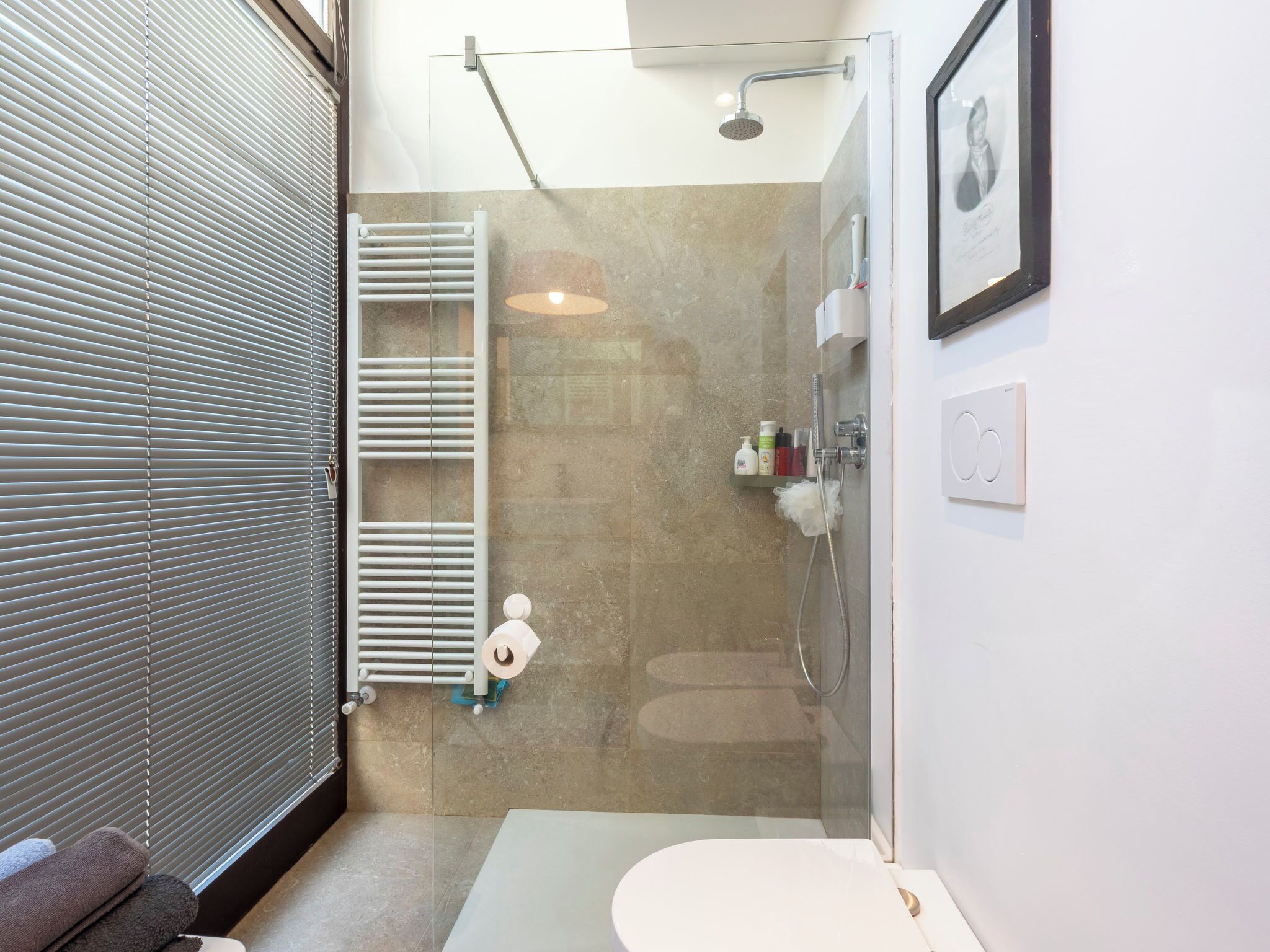 Ein modernes Badezimmer mit Dusche, Toilette und Handtuchhalter.