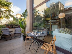 A modern patio with a round table, two chairs, a sofa, and a bookshelf. - NoLo Garden Loft by Interhome (Milan)