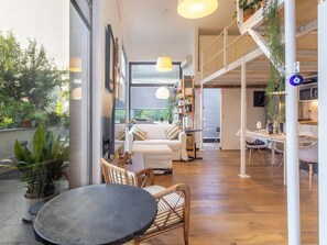 A modern living space with a sofa, chairs, a dining area, and a staircase. - NoLo Garden Loft by Interhome (Milan)
