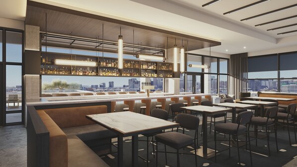 A modern bar area with seating and a city view.