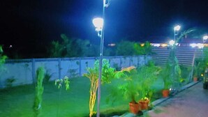 A paved walkway with street lamps and potted plants. - Matoshree Villa (Kotra)