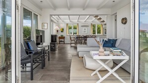 A spacious living area with a sofa, coffee table, and dining table. - Lovely cottage with amazing sea view (Assens)
