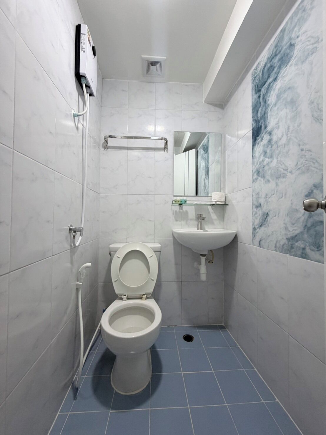 A bathroom with a toilet, sink, and shower.