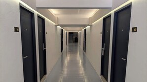 Un largo y estrecho pasillo de hotel con puertas numeradas 101 y 102, que conduce a habitaciones.