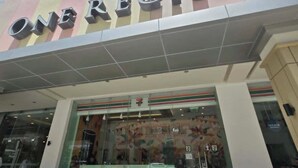 A building with a sign reading 'ONREGIS' and a 7-Eleven store at the entrance.