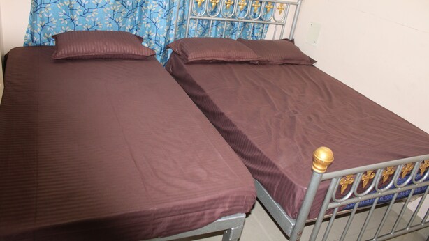 Een tweepersoonsbed met metalen frame en hoofdeinde met decoratieve details.