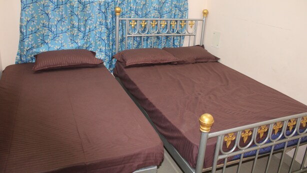 A single bed with a metal frame and a headboard with decorative elements. - Sri Arunachala Homestay (Tiruvannamalai)