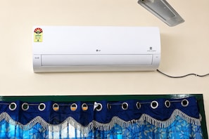 Un aire acondicionado de pared con panel de control y cable de alimentación.