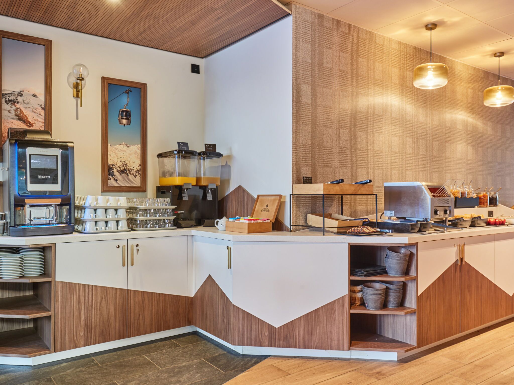 Un espace cuisine moderne équipé d’une machine à café, d’un coin pour préparer le thé et de divers produits alimentaires.