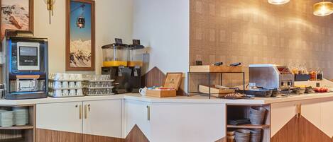 Un espace cuisine moderne équipé d’une machine à café, d’un coin pour préparer le thé et de divers produits alimentaires.