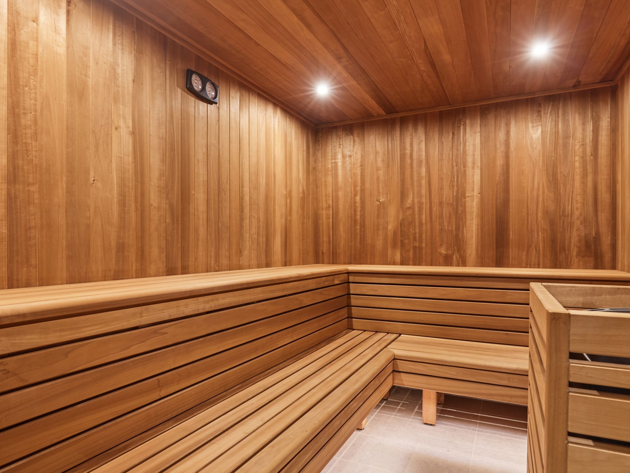 Una sauna con bancos de madera y un reloj en la pared.