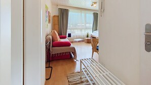 A room with a bed, a desk, a chair, and a window with curtains. - Flüela Lounge by Interhome (Davos)