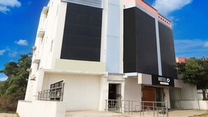 A modern hotel with a prominent 'HOTEL' sign, large windows, and a flat facade. - Premium Ssm Murugan Rooms (Sriperumbudur)