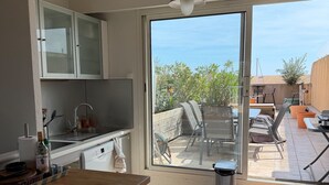 Eine Küche mit Fenster zu einer Terrasse.