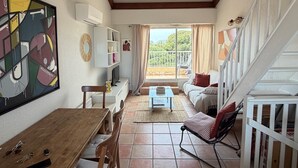 Ein gemütliches Wohnzimmer mit Essbereich, einer Treppe und einem Balkon mit Blick.