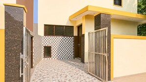 A narrow corridor with tiled flooring and metal gates on both sides. - Townhouse Sector 13 Gurgaon (Gurugram)