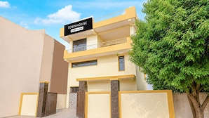 A two-story building with a sign reading 'TOWNHOUSE OYO-Serviced'. - Townhouse Sector 13 Gurgaon (Gurugram)